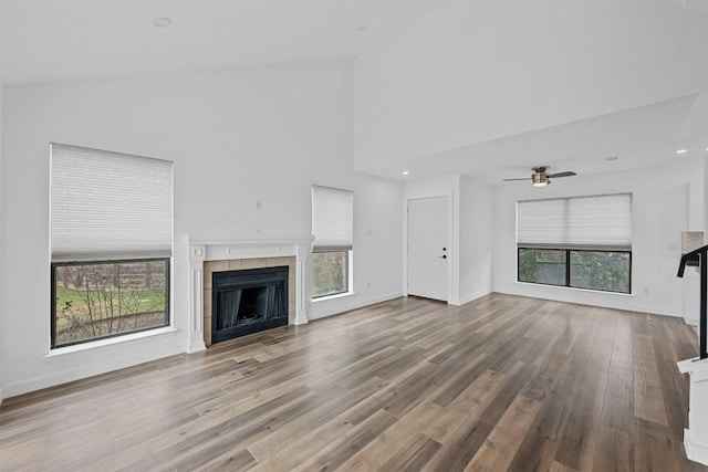 2018 W Rundberg Ln Unit 9D, Austin, TX 78758 - unfurnished living room with a fireplace, plenty of natural light, wood finished floors, high vaulted ceiling, and ceiling fan