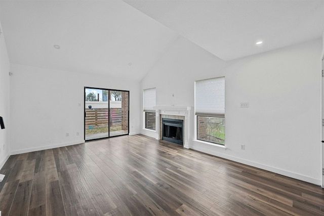 2018 W Rundberg Ln Unit 9D, Austin, TX 78758 - unfurnished living room featuring a tile fireplace, wood finished floors, baseboards, high vaulted ceiling, and recessed lighting