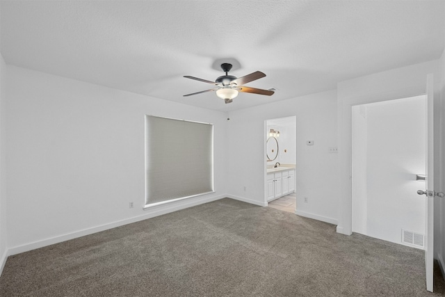 2018 W Rundberg Ln Unit 9D, Austin, TX 78758 - unfurnished bedroom with light carpet, connected bathroom, a sink, ceiling fan, and baseboards