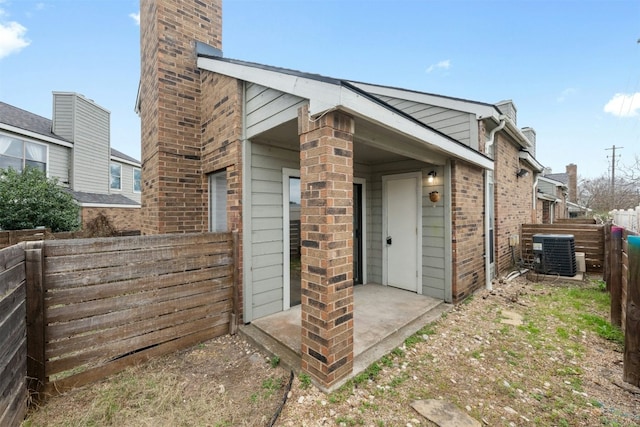 2018 W Rundberg Ln Unit 9D, Austin, TX 78758 - view of side of property with central air condition unit, brick siding, and a fenced backyard