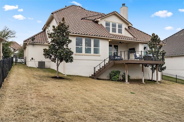 back of property featuring a wooden deck, a lawn, and central air condition unit