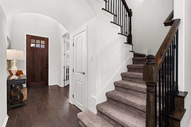 entrance foyer with lofted ceiling and dark hardwood / wood-style floors