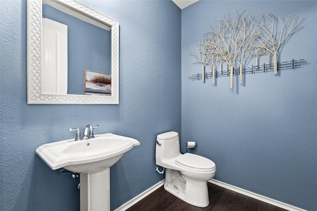 bathroom with hardwood / wood-style flooring and toilet