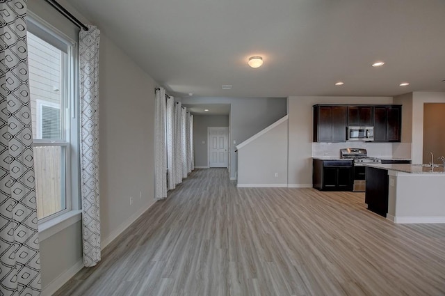 kitchen with recessed lighting, baseboards, light wood finished floors, and stainless steel appliances