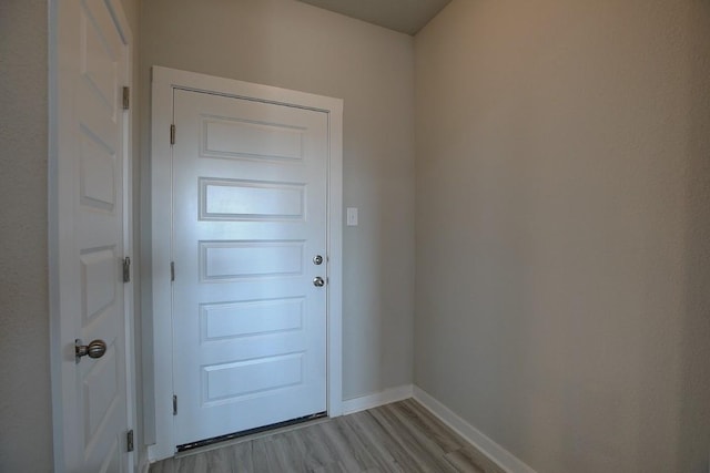 doorway to outside with baseboards and light wood-style floors