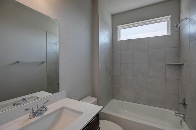 full bath with vanity, toilet, shower / bathing tub combination, and a textured wall