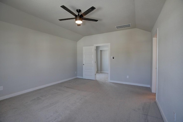 empty room featuring visible vents, ceiling fan, baseboards, lofted ceiling, and carpet floors