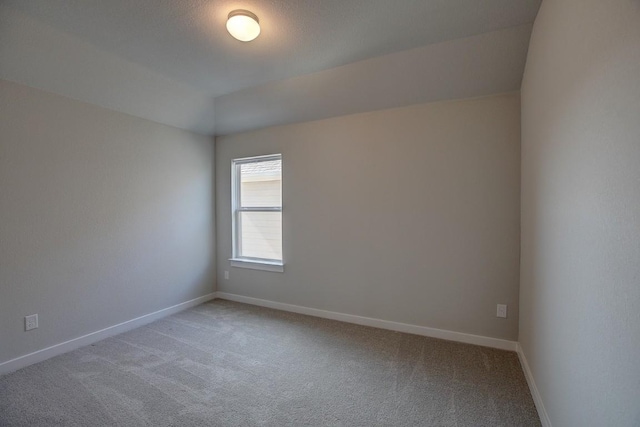 unfurnished room with baseboards and light carpet