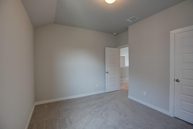 interior space with visible vents, carpet flooring, lofted ceiling, and baseboards