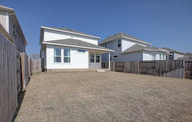 rear view of property featuring a fenced backyard and roof with shingles