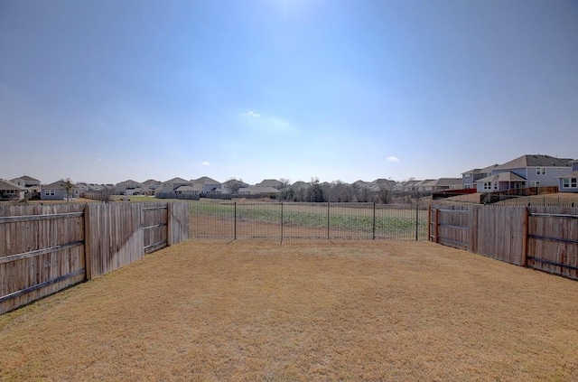 view of yard with a residential view and a fenced backyard