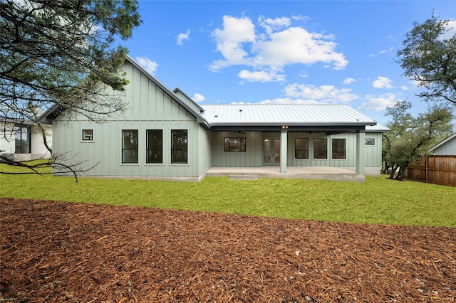 back of house with a lawn and a patio