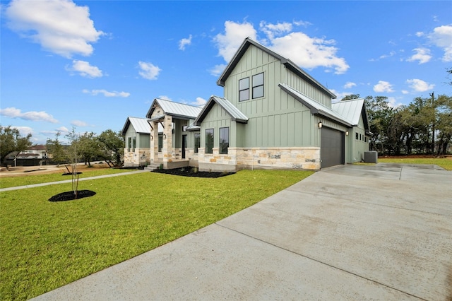 view of front of property with a garage, a front yard, and central air condition unit