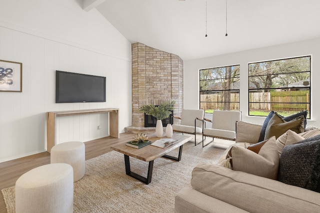 living room featuring beamed ceiling, high vaulted ceiling, and light hardwood / wood-style floors