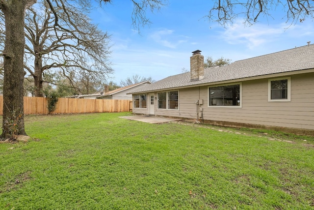 rear view of property featuring a yard and a patio area