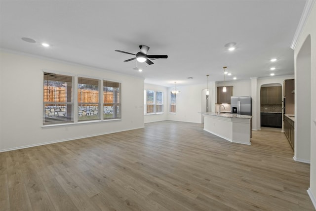 unfurnished living room with sink and crown molding