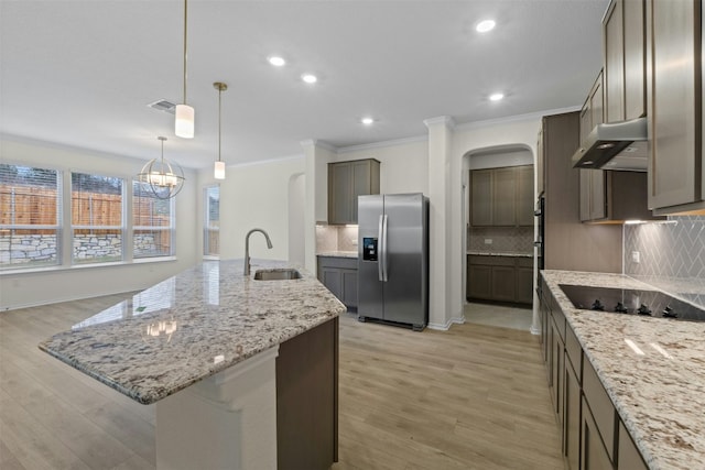 kitchen with sink, stainless steel fridge with ice dispenser, hanging light fixtures, a large island with sink, and light hardwood / wood-style floors