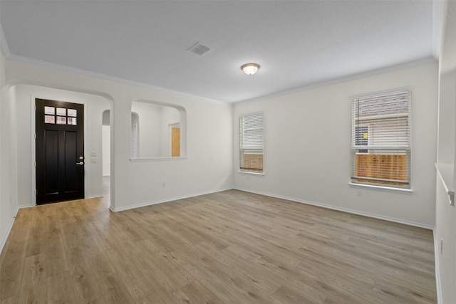 foyer entrance with crown molding and light hardwood / wood-style floors