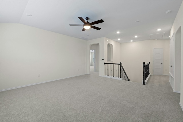 spare room featuring lofted ceiling, light carpet, and ceiling fan