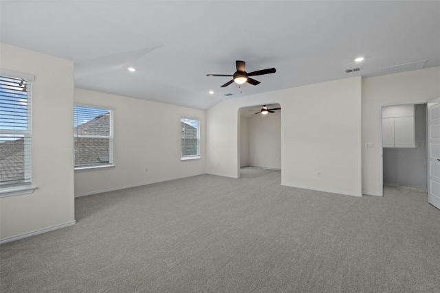 carpeted spare room with lofted ceiling, a healthy amount of sunlight, and ceiling fan