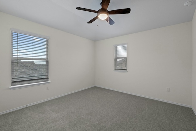 carpeted spare room featuring ceiling fan