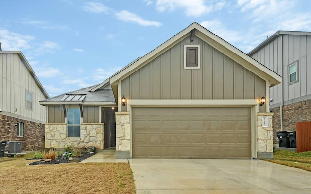 view of front of home featuring a garage and central air condition unit