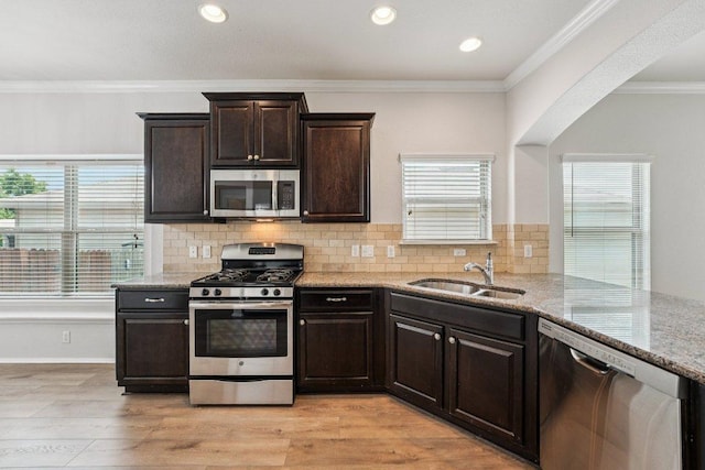 10017 Pinnacle Crest Loop, Austin, TX 78747 - kitchen with stainless steel appliances, a sink, light stone countertops, dark brown cabinets, and tasteful backsplash