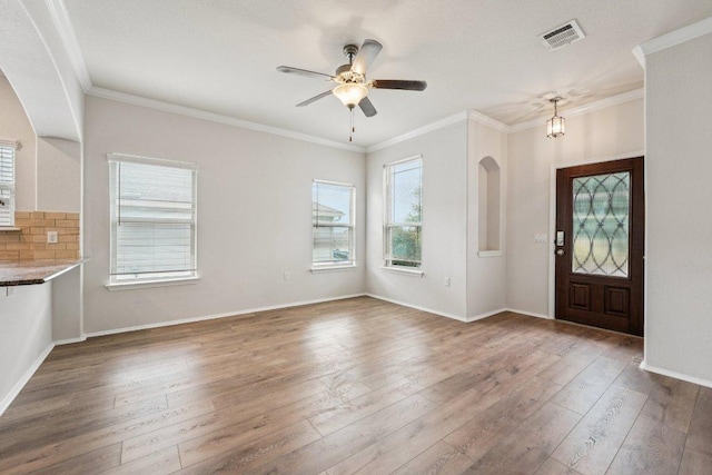 10017 Pinnacle Crest Loop, Austin, TX 78747 - entrance foyer featuring wood finished floors, crown molding, a ceiling fan, arched walkways, and baseboards