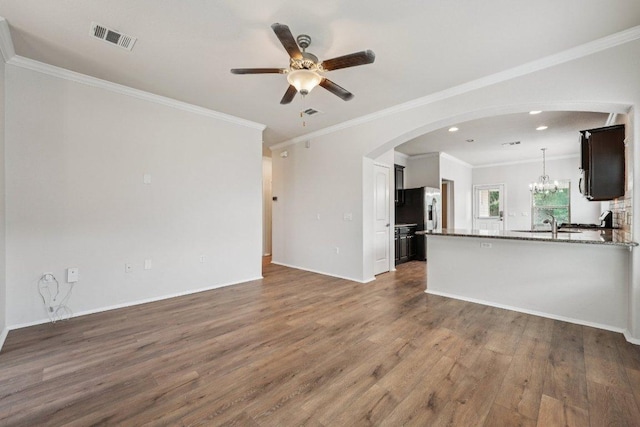 10017 Pinnacle Crest Loop, Austin, TX 78747 - unfurnished living room featuring arched walkways, wood finished floors, a ceiling fan, recessed lighting, and crown molding