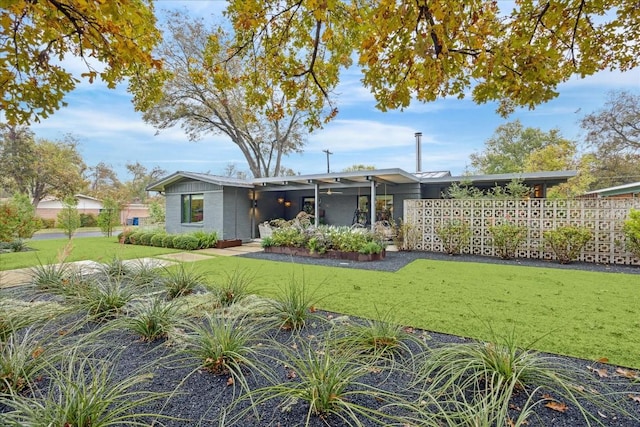 rear view of property featuring a lawn