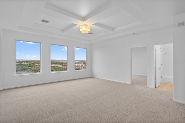 unfurnished room with light colored carpet, coffered ceiling, and a wealth of natural light