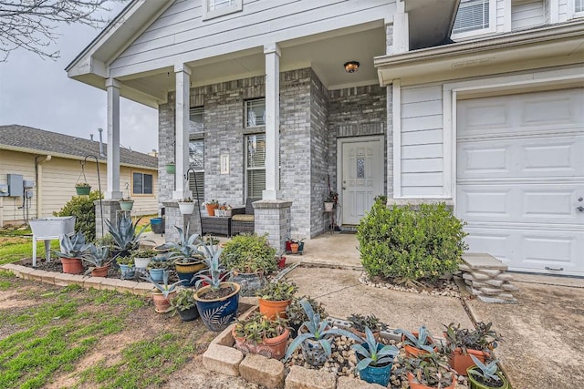 12828 Starbrimson Trl, Elgin, TX 78621 - view of exterior entry with a garage and covered porch