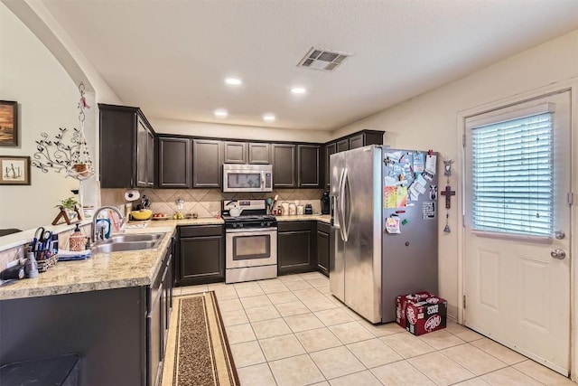 12828 Starbrimson Trl, Elgin, TX 78621 - kitchen featuring stainless steel appliances, a sink, light tile patterned flooring, and light countertops