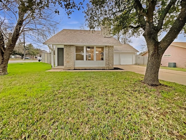 view of front of house with a front yard, a garage, and central air condition unit