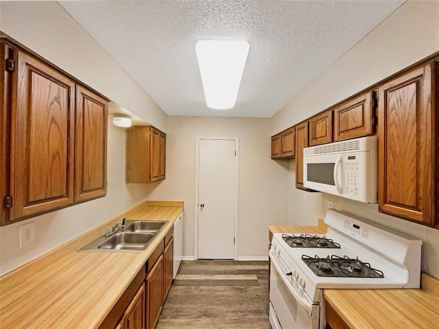 6234 Hillston Dr, Austin, TX 78745 - kitchen with white appliances, brown cabinets, a textured ceiling, light countertops, and dark wood-style floors