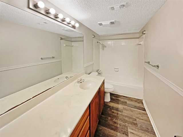 6234 Hillston Dr, Austin, TX 78745 - full bathroom with a textured ceiling, vanity,  shower combination, and wood finished floors