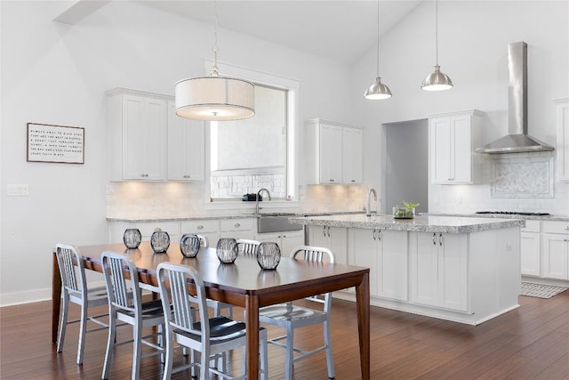 1821 Overland Stage Rd, Dripping Springs, TX 78620 - kitchen featuring wall chimney exhaust hood, a sink, a center island with sink, decorative backsplash, and white cabinets