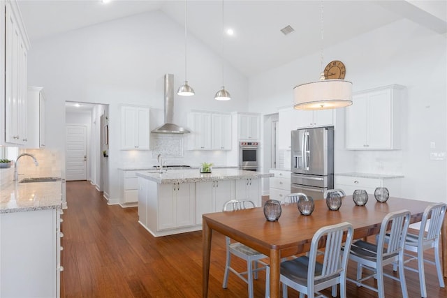 1821 Overland Stage Rd, Dripping Springs, TX 78620 - kitchen featuring stainless steel appliances, wall chimney exhaust hood, a sink, high vaulted ceiling, and an island with sink