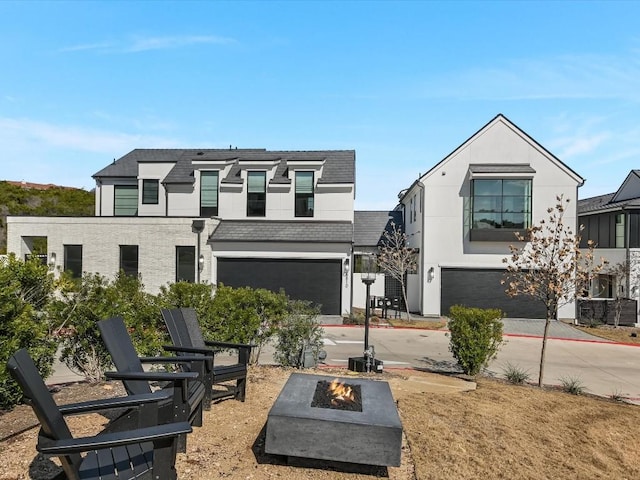 view of front of property featuring a garage and an outdoor fire pit