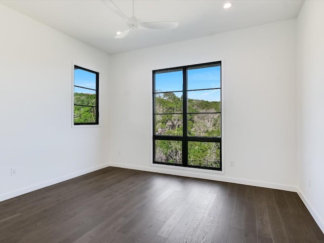 spare room with plenty of natural light, dark hardwood / wood-style floors, and ceiling fan