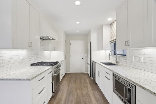 kitchen featuring white cabinetry, stainless steel appliances, sink, and light stone counters