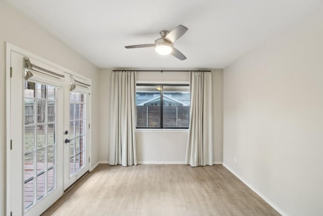 empty room with french doors, ceiling fan, and light wood-type flooring