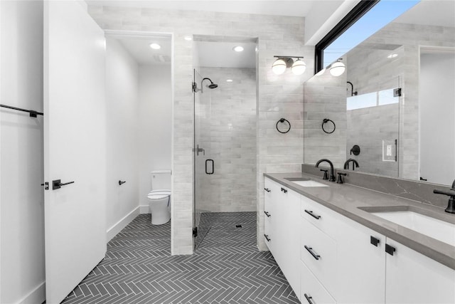 bathroom featuring vanity, a shower with door, and toilet