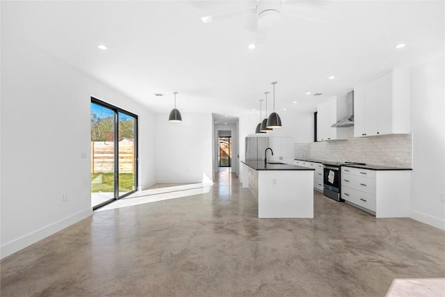 kitchen featuring concrete floors, stainless steel electric stove, dark countertops, and wall chimney range hood