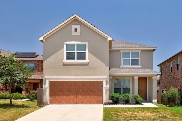 view of front property featuring a garage, a front lawn, and solar panels