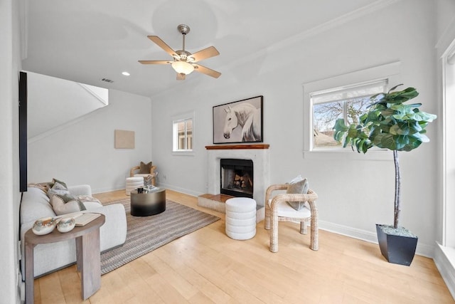 living room featuring ornamental molding, hardwood / wood-style floors, and ceiling fan