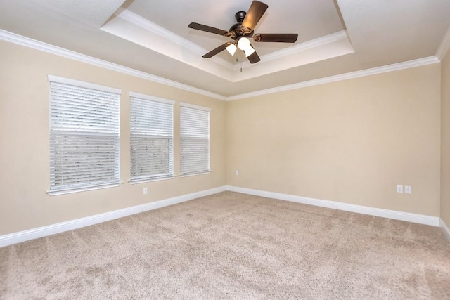 carpeted empty room with a tray ceiling, ornamental molding, and ceiling fan