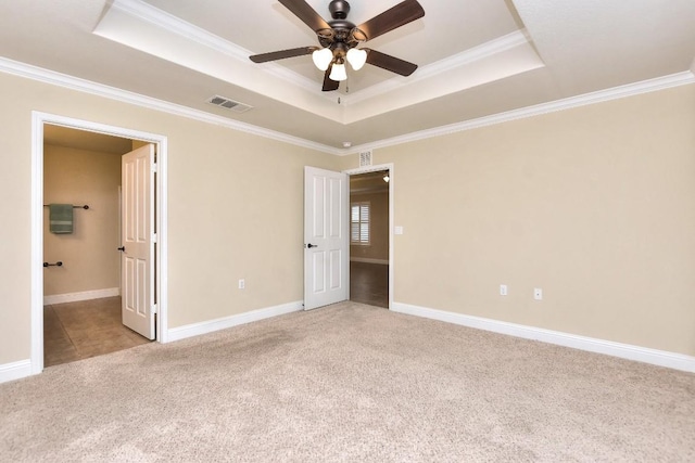 unfurnished bedroom with light carpet, crown molding, a raised ceiling, and ceiling fan