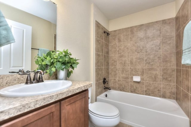 full bathroom with vanity, tiled shower / bath combo, and toilet