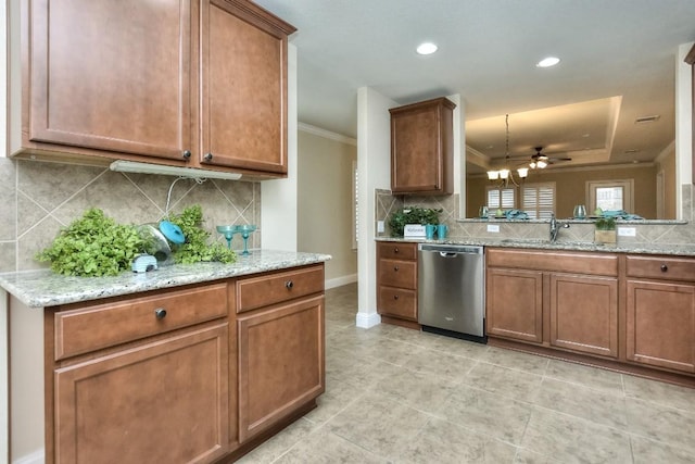 kitchen with light stone counters, ornamental molding, a tray ceiling, dishwasher, and backsplash